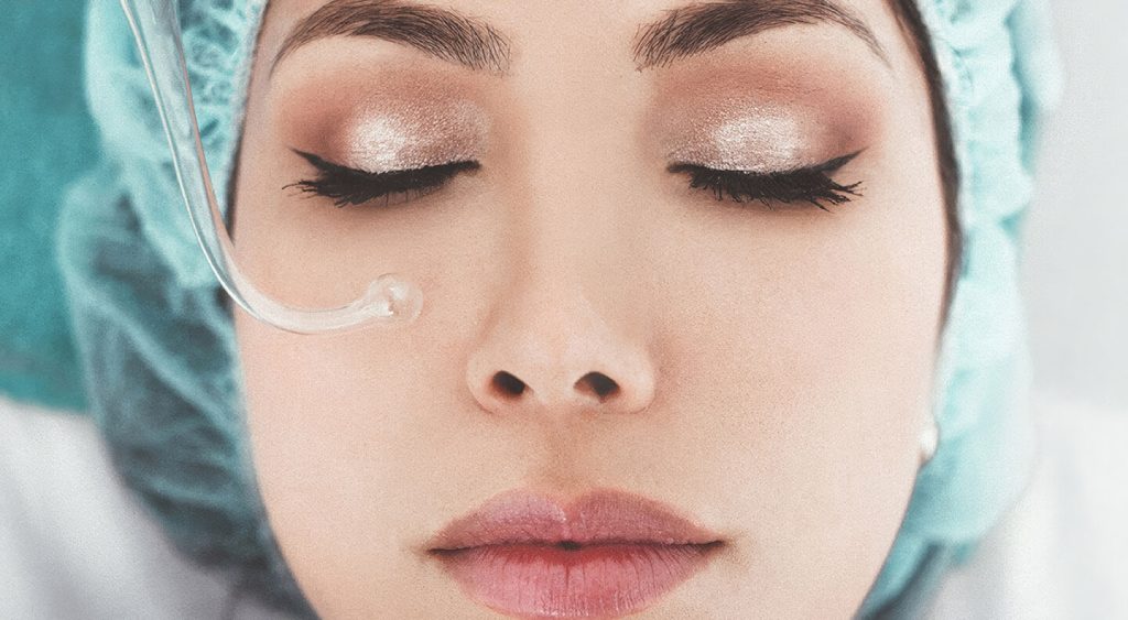 Close-up of a woman’s face with eyes closed during a professional facial treatment.