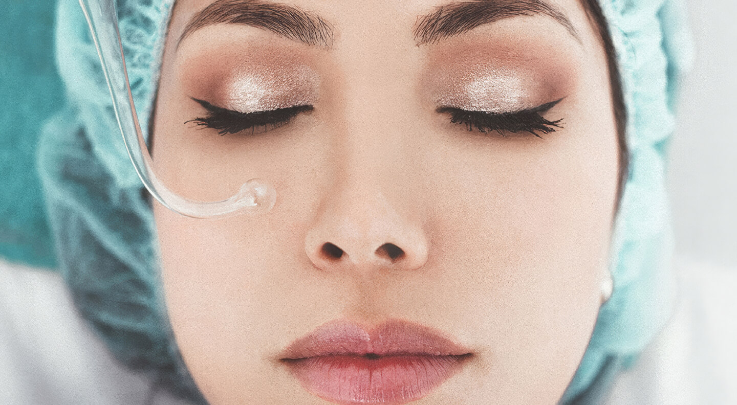 Close-up of a woman’s face with eyes closed during a professional facial treatment.